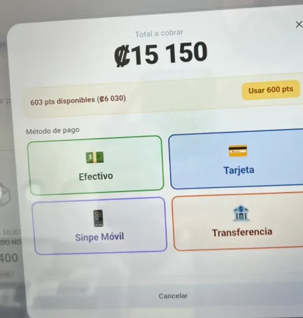 Foto de teléfono de la pantalla de la caja en medio de un cobro: el modal de pago de SimplePOS con el total, los puntos de lealtad y los métodos de pago.
