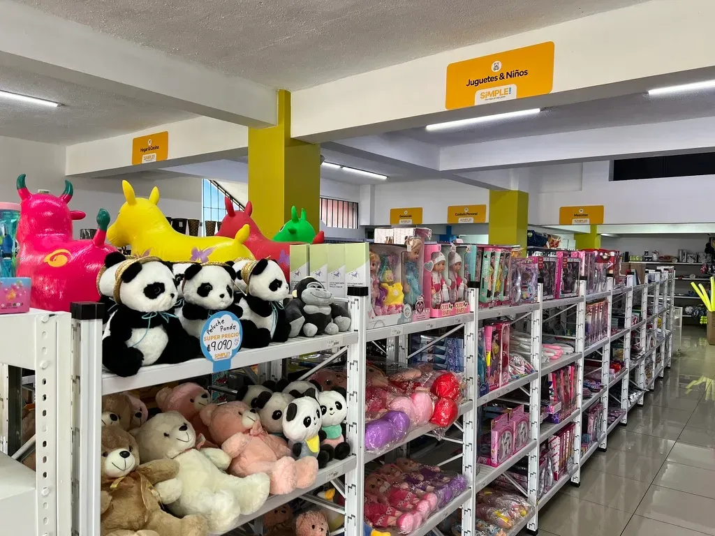 Una punta de góndola de juguetes con peluches y cajas de juguetes, con precio y acomodados para la venta.